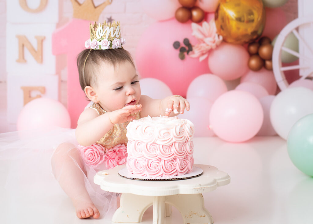 Focused expression as birthday girl plays with cake during her themed photoshoot