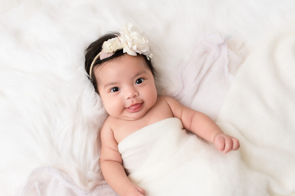 Baby girl smiling in soft tulle dress with white headband