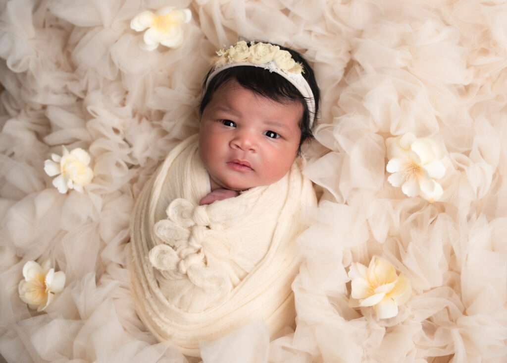 Baby girl on cream fur with yellow floral accents