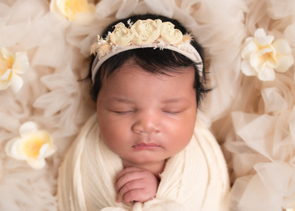 Close-up of baby wrapped in ivory with full floral crown