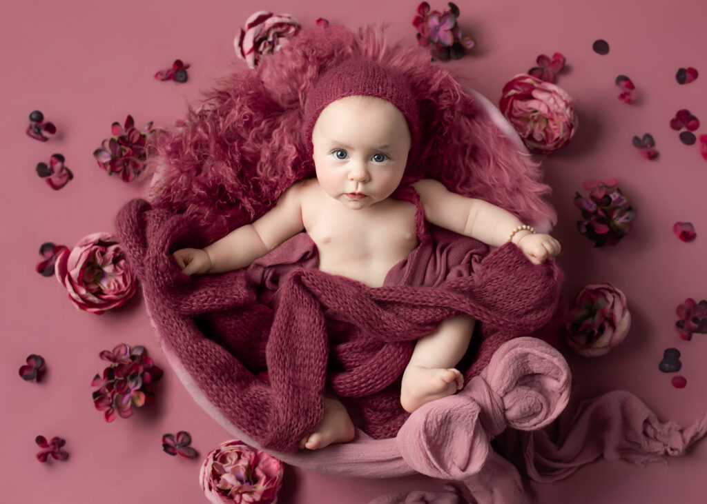 3 month old baby girl on mauve background with plum florals and knotted wrap