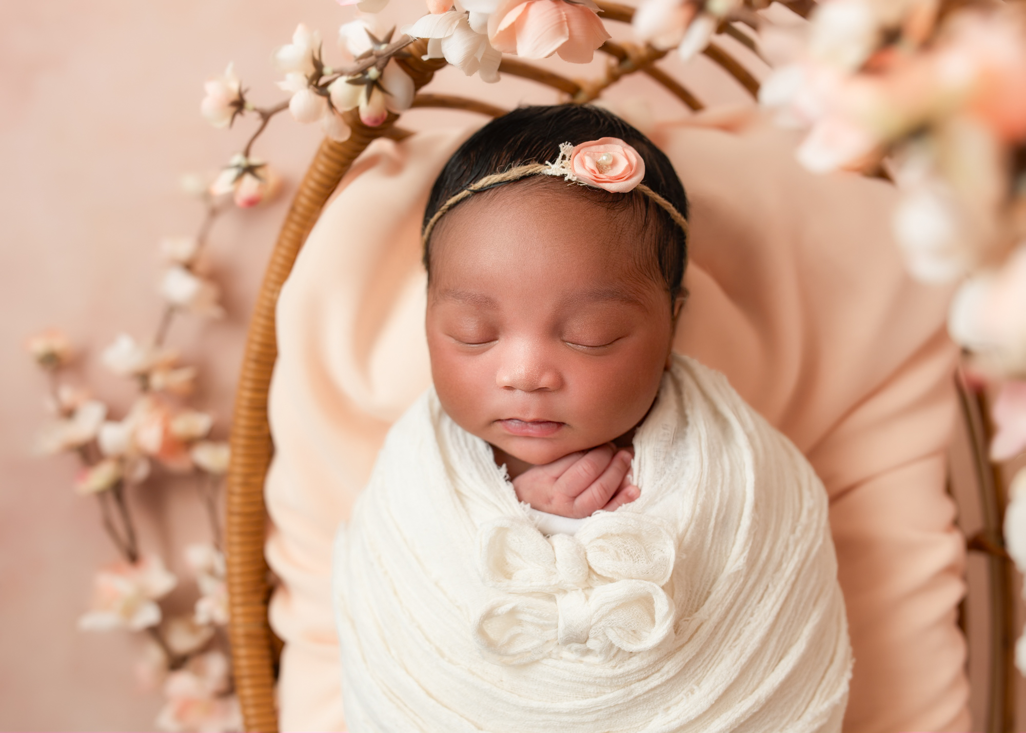 Fully styled newborn mini session setup with floral tones and gentle lighting)