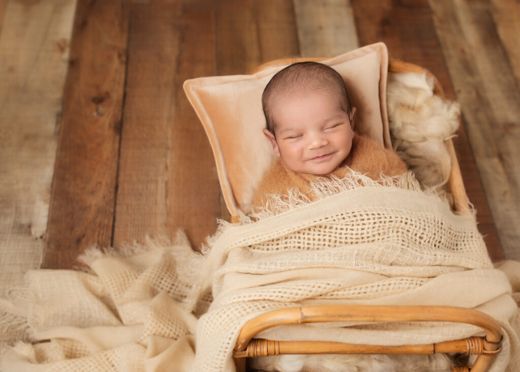 Newborn baby swaddled in a soft blanket, peacefully sleeping in a cozy basket, surrounded by natural tones