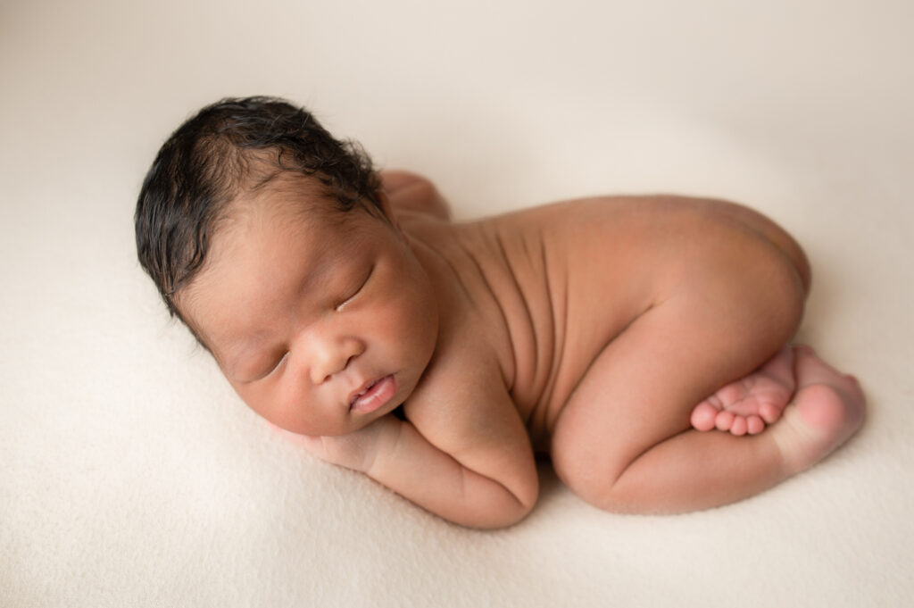 Close up of baby with an emphasis on facial features, tiny toes, baby soft skin, and back rolls.