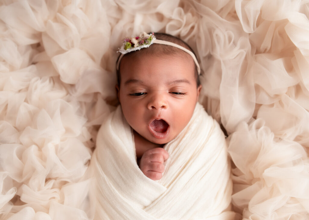 From maternity to newborn portrait of wrapped newborn posed on tan flokati, Birmingham newborn session