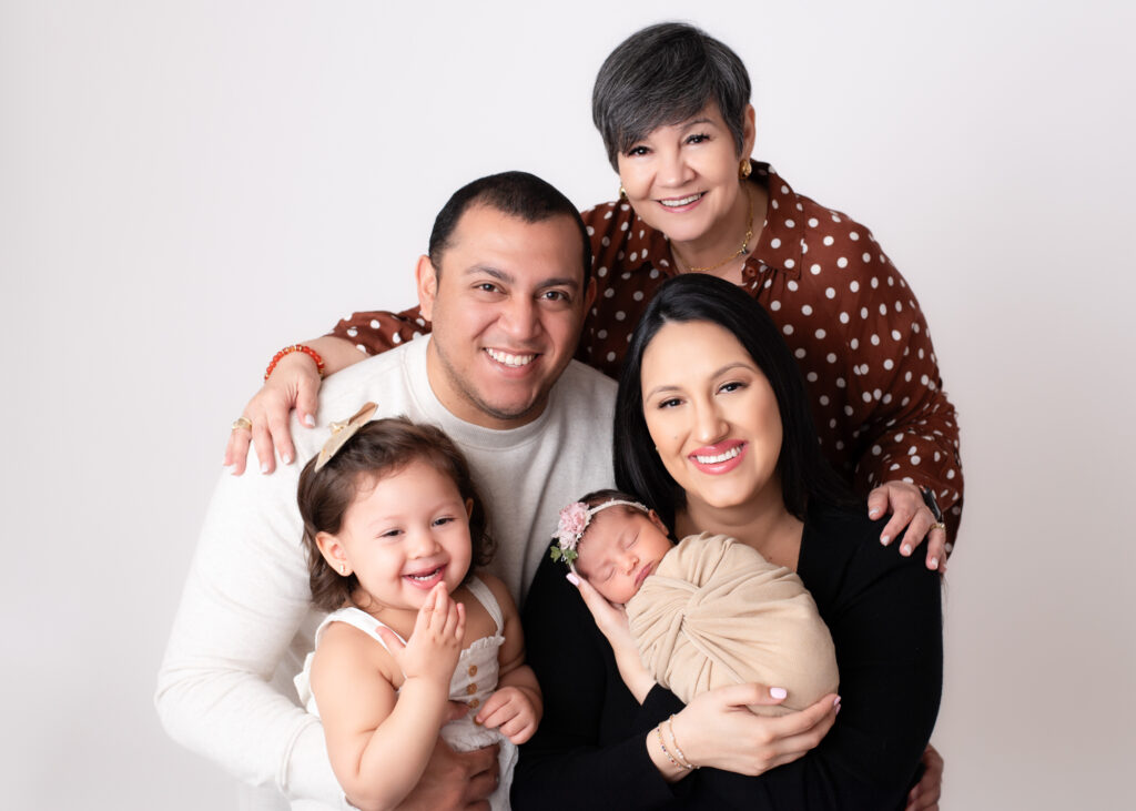 Family of 5 posing with their newborn baby girl and toddler daughter.