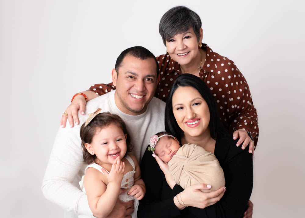 Family of 5 posing with their newborn baby girl and toddler daughter.