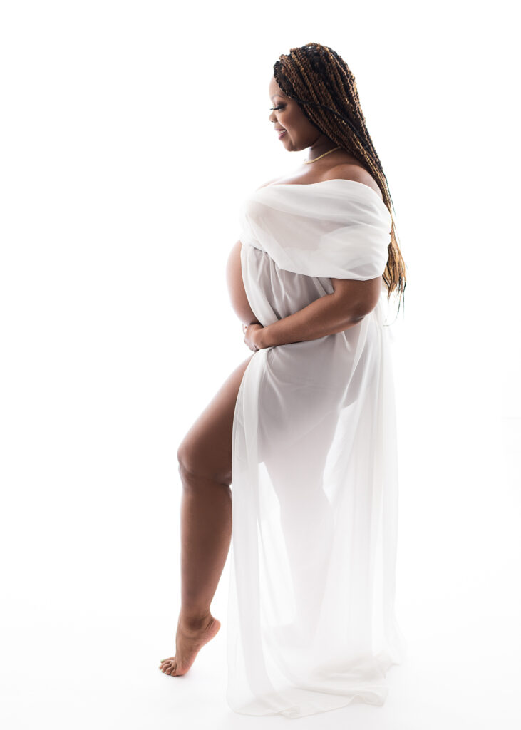 A maternity photo of a pregnant mother captured in a soft, high-key studio style in Birmingham, AL.
