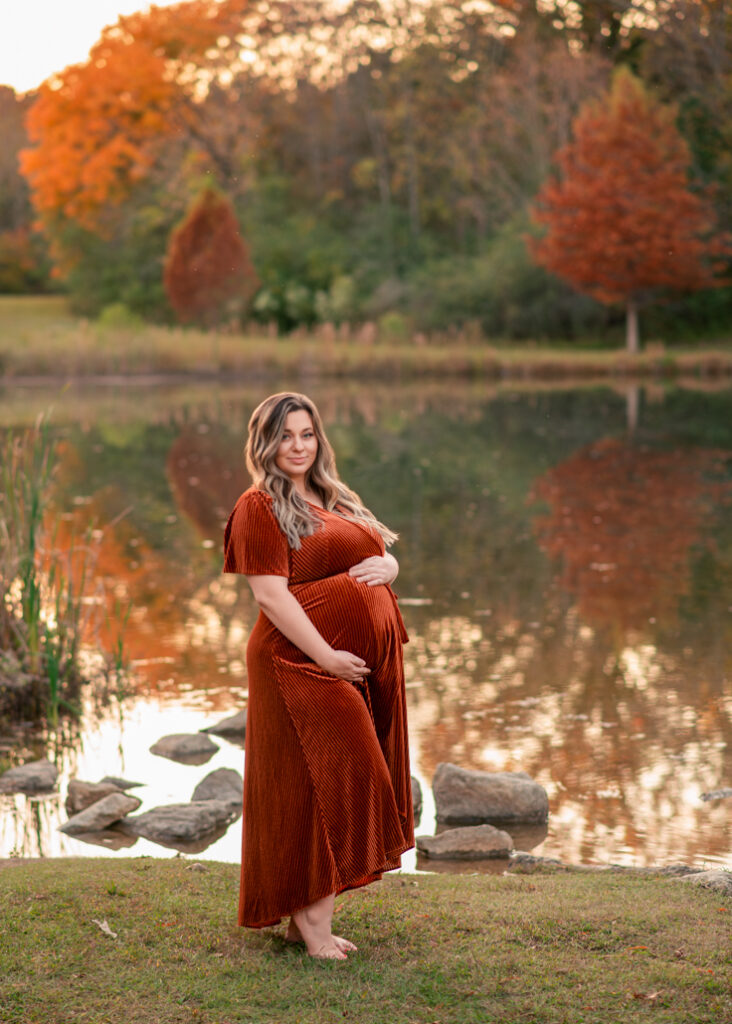 Full-length portrait of expectant mom in rust velvet dress at Birmingham fall maternity mini session
