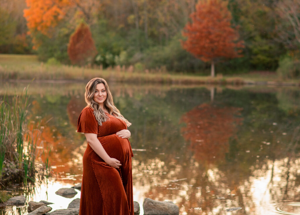 Pregnant mom in rust velvet dress by the lake, Birmingham fall mini sessions.