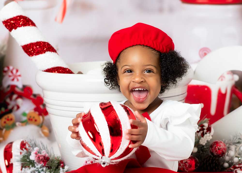 Close-up portrait of a toddler in a red beret on the peppermint Hot Cocoa studio set, Birmingham, AL.