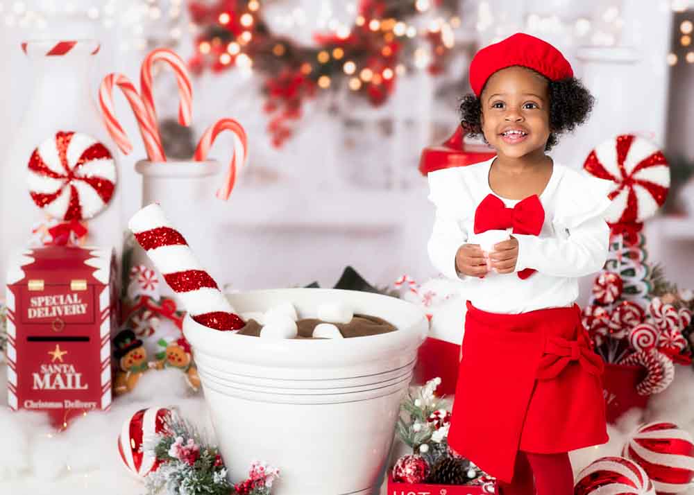 Toddler smiling with candy canes and twinkle lights in the background—Book the Look Hot Cocoa, Birmingham, AL.