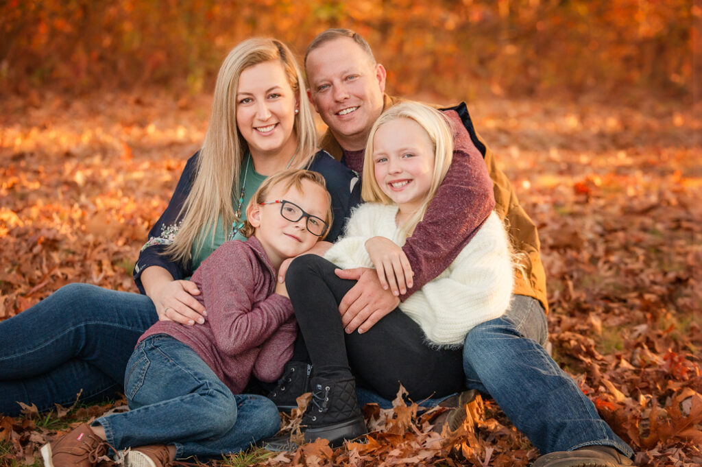 Family in golden fall leaves